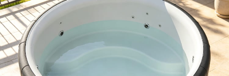 1776739597255566.png Close-up view of portable round spa tub with massage jets, light blue water, outdoor terrace.png